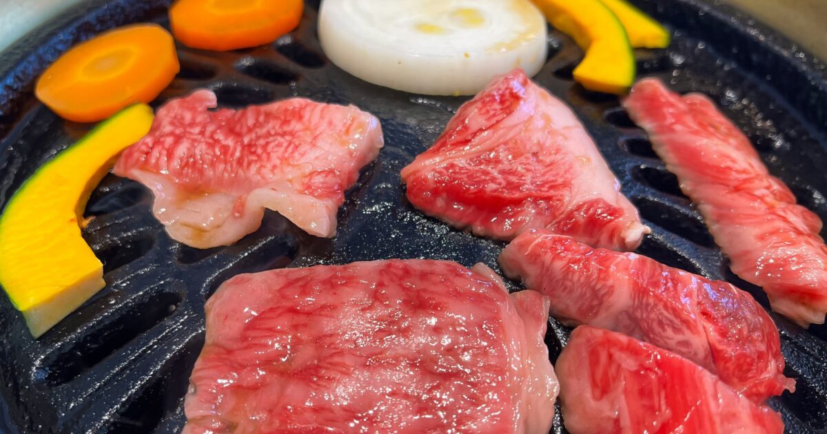 鉄板で焼かれる霜降り牛肉と野菜