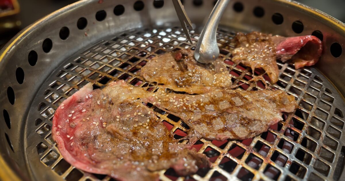 網焼きで焼かれる薄切りカルビ肉