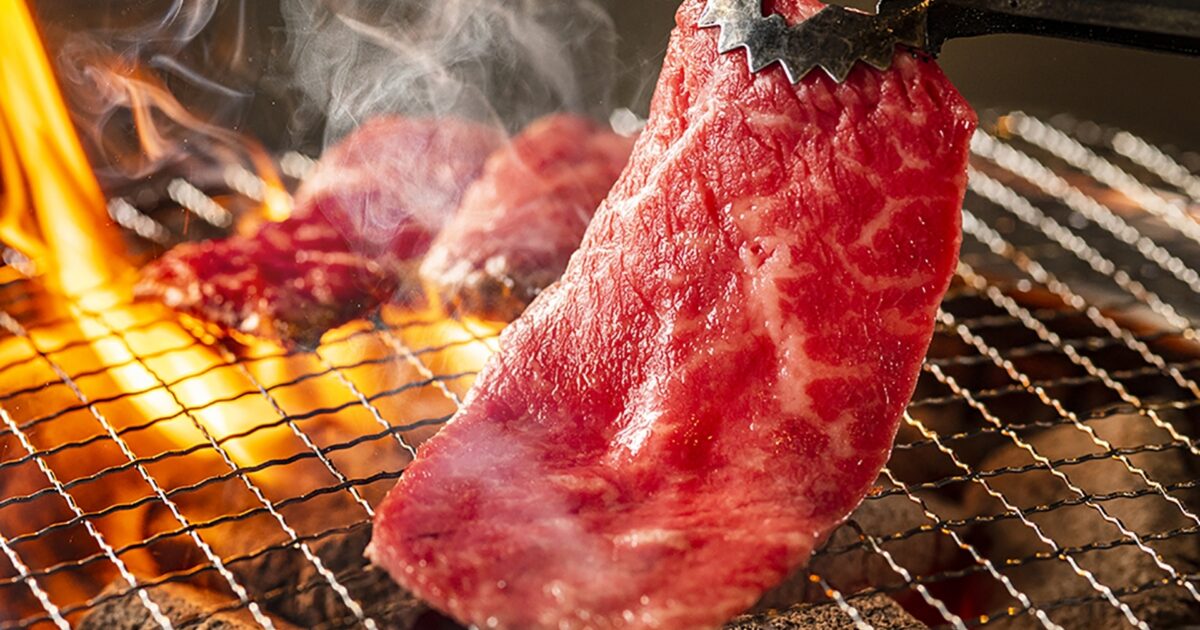 炭火で焼かれる霜降り焼肉と立ち上る炎