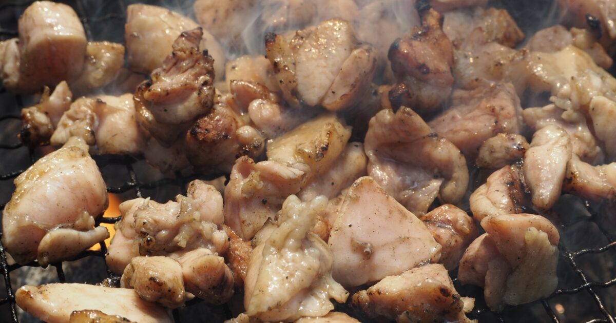 炭火で香ばしく焼かれる一口サイズの鶏もも肉
