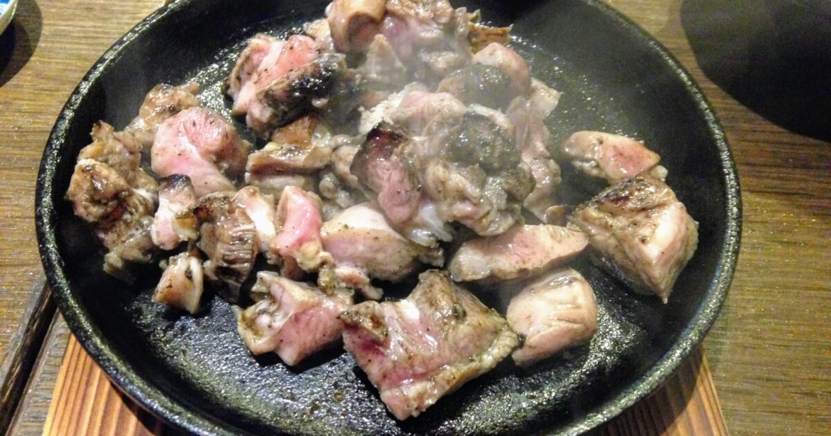 鉄板に盛られた宮崎地鶏の炭火焼き盛り合わせ