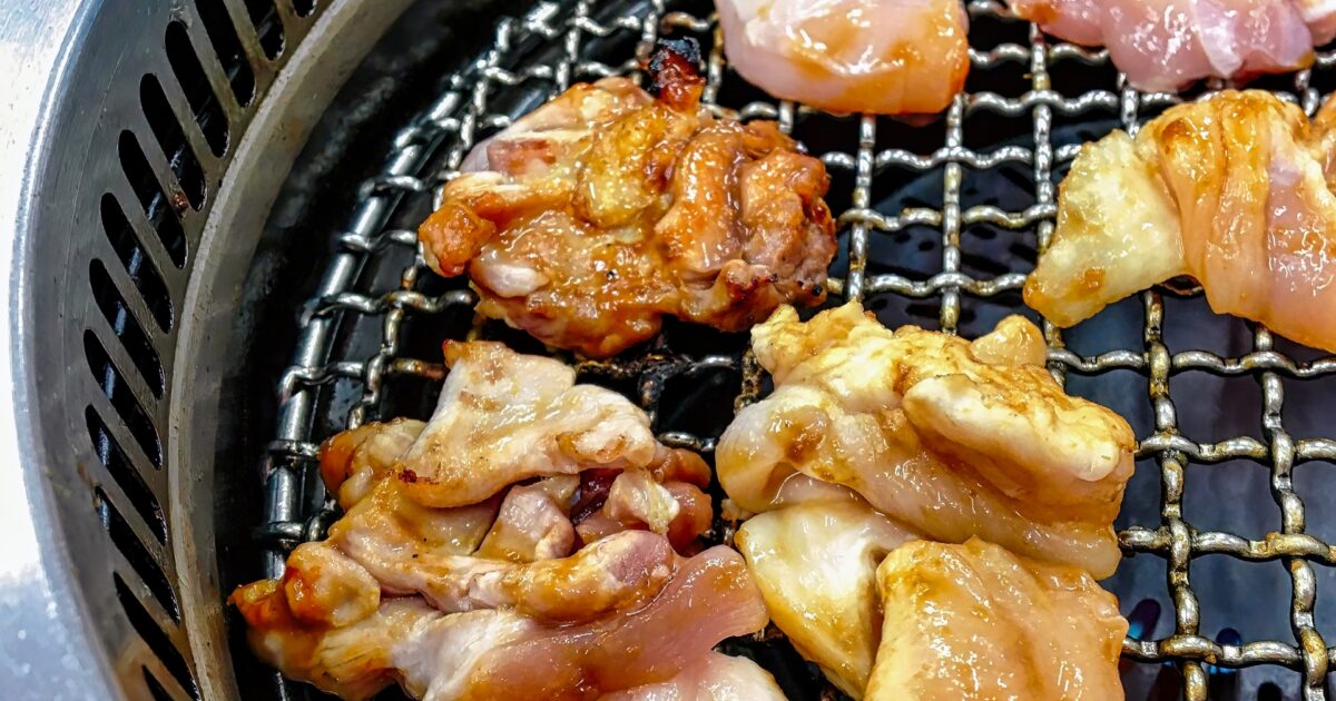 焼き始めた鶏もも肉が網で香ばしく焼かれる様子