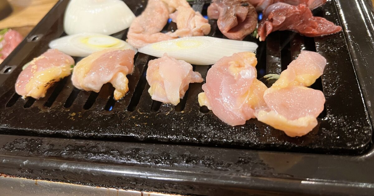 鶏肉と玉ねぎを鉄板で焼く焼肉スタイルの盛り合わせ