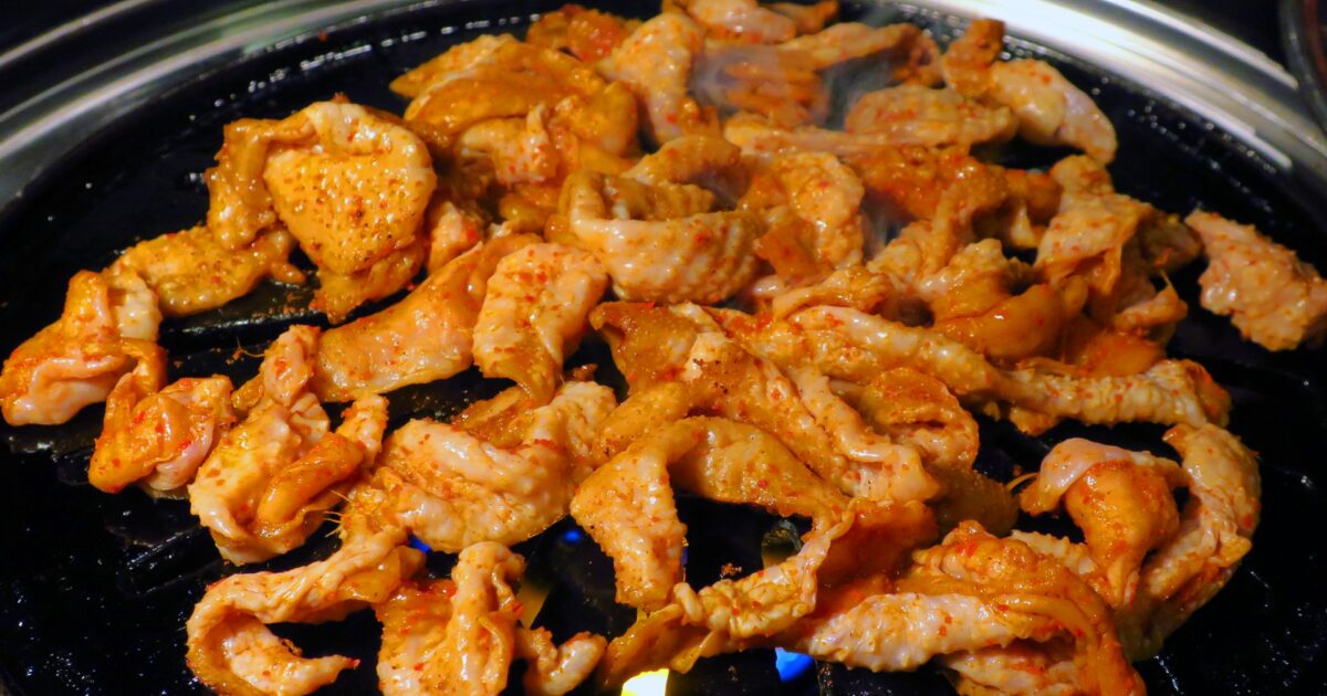 ピリ辛だれで味付けされた鶏皮の鉄板焼き