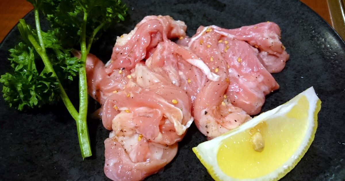 ごま入り塩だれがかかった鶏肉とレモンの盛り合わせ