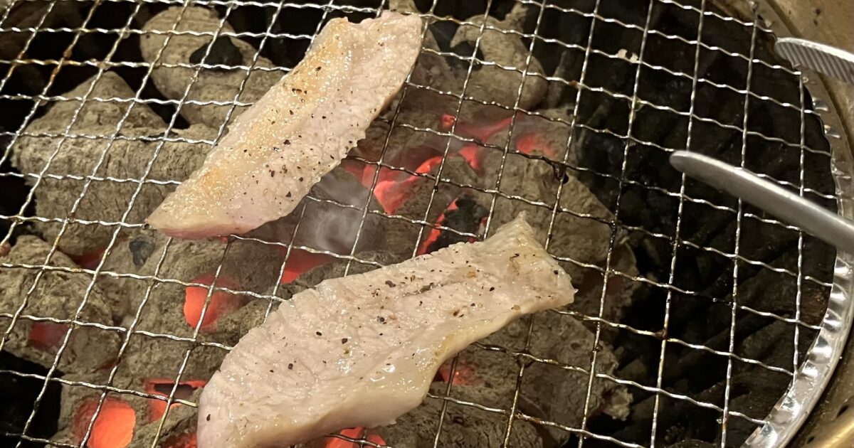 炭火で焼かれる塩味の豚肉焼肉プレート