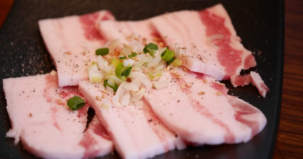 刻みネギと胡椒がのった豚バラ肉の焼肉用スライス