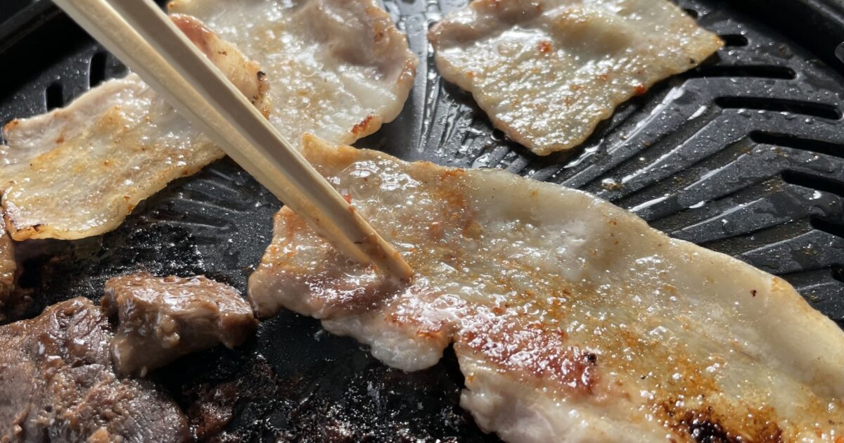 ホットプレートで焼かれる豚バラ肉と牛肉