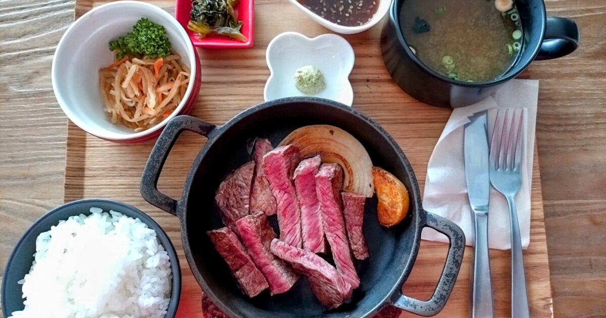 鉄鍋で提供されるステーキ定食と味噌汁の和風ランチ