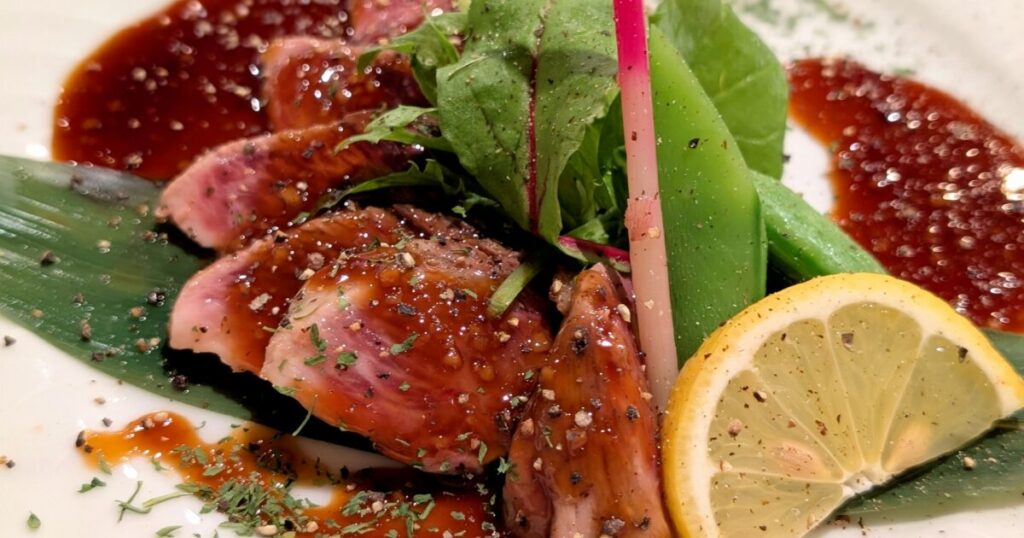 照り焼きソースがかかった和風ステーキとレモン添え